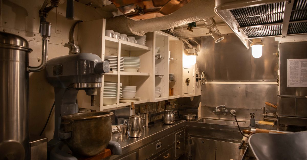 Cocina industrial con mesadas de acero inoxidable y equipamiento de acero